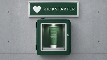 SKØN Repair Microbiome cream in a green glass-front cabinet on grey concrete beneath a KICKSTARTER sign.