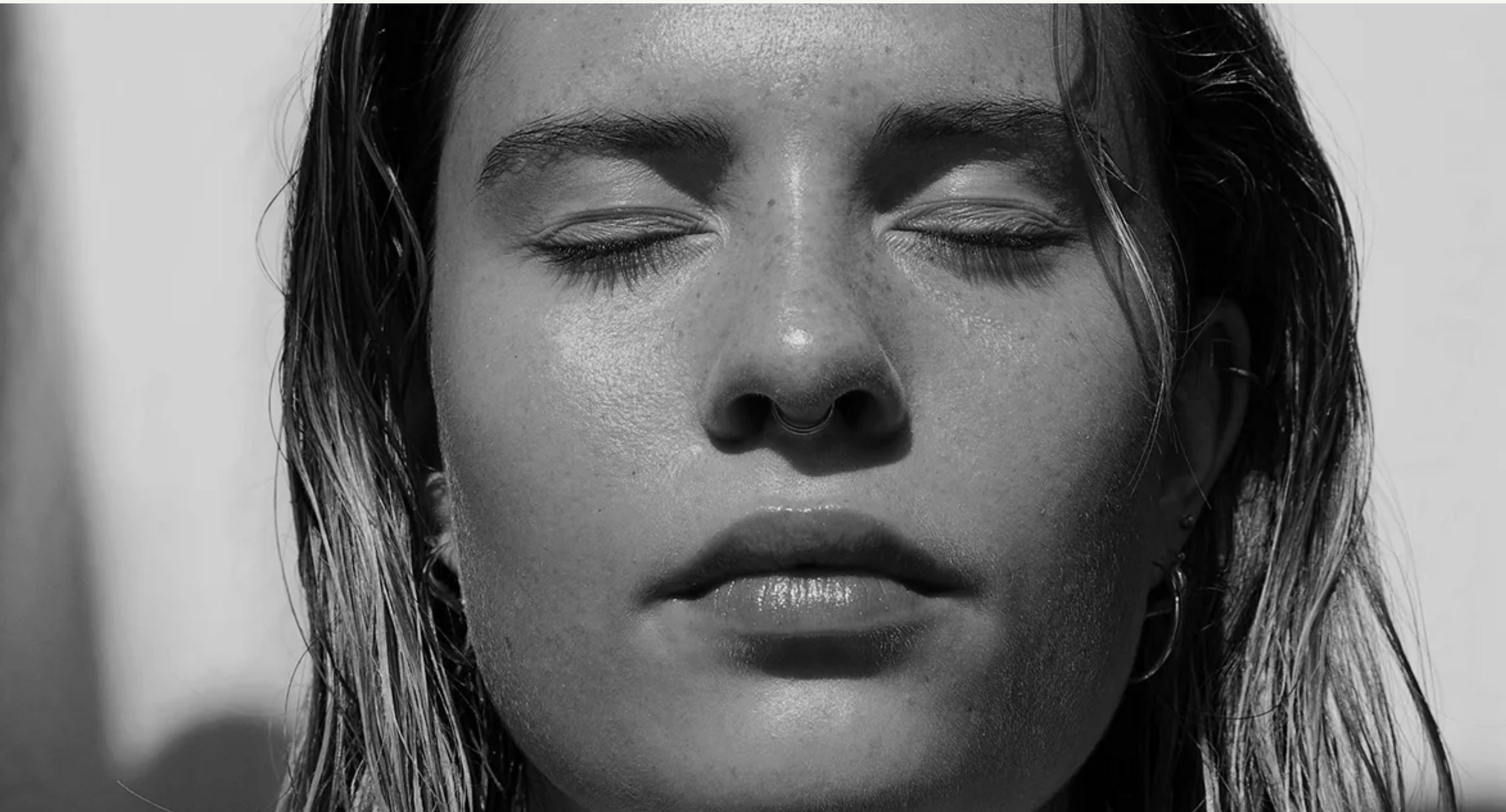 Black and white close-up of a person with eyes closed