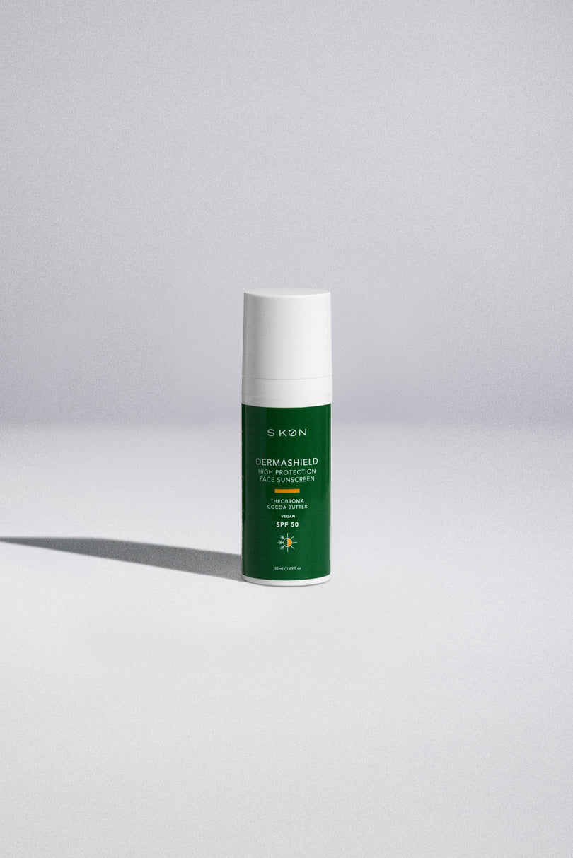 Green skincare bottle with white cap on a light gray background