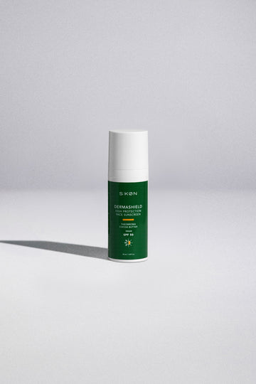 Green skincare bottle with white cap on a light gray background